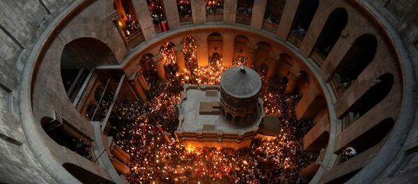 Worshippers hold candles as they take part in the Christian Orthodox Holy Fire ceremony at the Church of the Holy Sepulchre in Jerusalem's Old City - Sputnik International