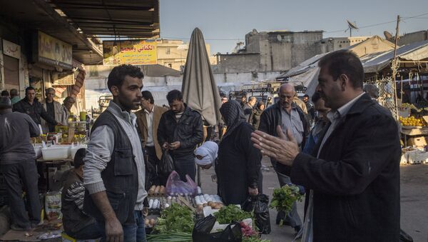 A man talks to a seller at a Damascus market. File photo - Sputnik International