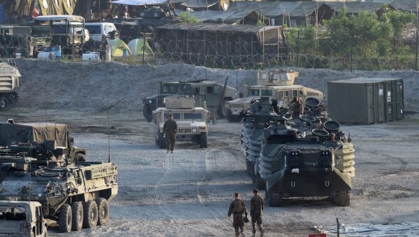 This file photo taken on April 14, 2016 shows US marines walking next to their transport and amphibious vehicles at a temporary camp for the Balikatan joint US-Philippine military exercise at Crow Valley, in Capas town, north of Manila - Sputnik International