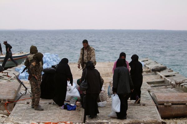 Syrian Democratic Forces (SDF) fighters relocate people that fled from Raqqa city on the bank of the Euphrates river, west of Raqqa city, Syria April 8, 2017 Syrian Democratic Forces (SDF) fighters relocate people that fled from Raqqa city on the bank of the Euphrates river, west of Raqqa city, Syria April 8, 2017 - Sputnik International