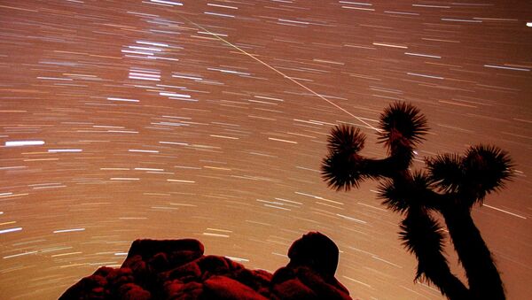 a meteor streaks through the sky over Joshua trees and rocks at Joshua Tree National Park in Southern California's Mojave Desert - Sputnik International