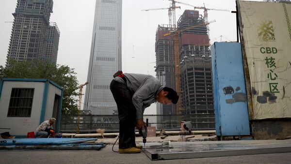 In this Sunday, April 16, 2017 photo, a worker assembles an aluminum platform outside a construction site at the Central Business District of Beijing - Sputnik International