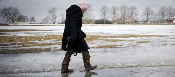 An elderly woman walks on melted snow in Djurgaarden area in Stockholm on March 21, 2011 An elderly woman walks on melted snow in Djurgaarden area in Stockholm on March 21, 2011 - Sputnik International