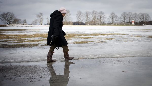 An elderly woman walks on melted snow in Djurgaarden area in Stockholm on March 21, 2011 - Sputnik International