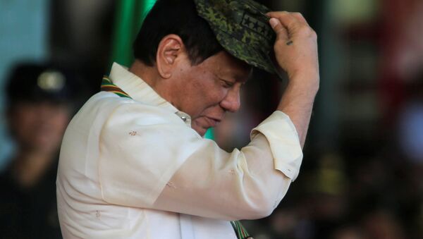 Philippine President Rodrigo Duterte tries on a military hat given to him during the 120th founding anniversary of the Philippine Army (PA) at Taguig city, metro Manila, Philippines April 4, 2017 - Sputnik International