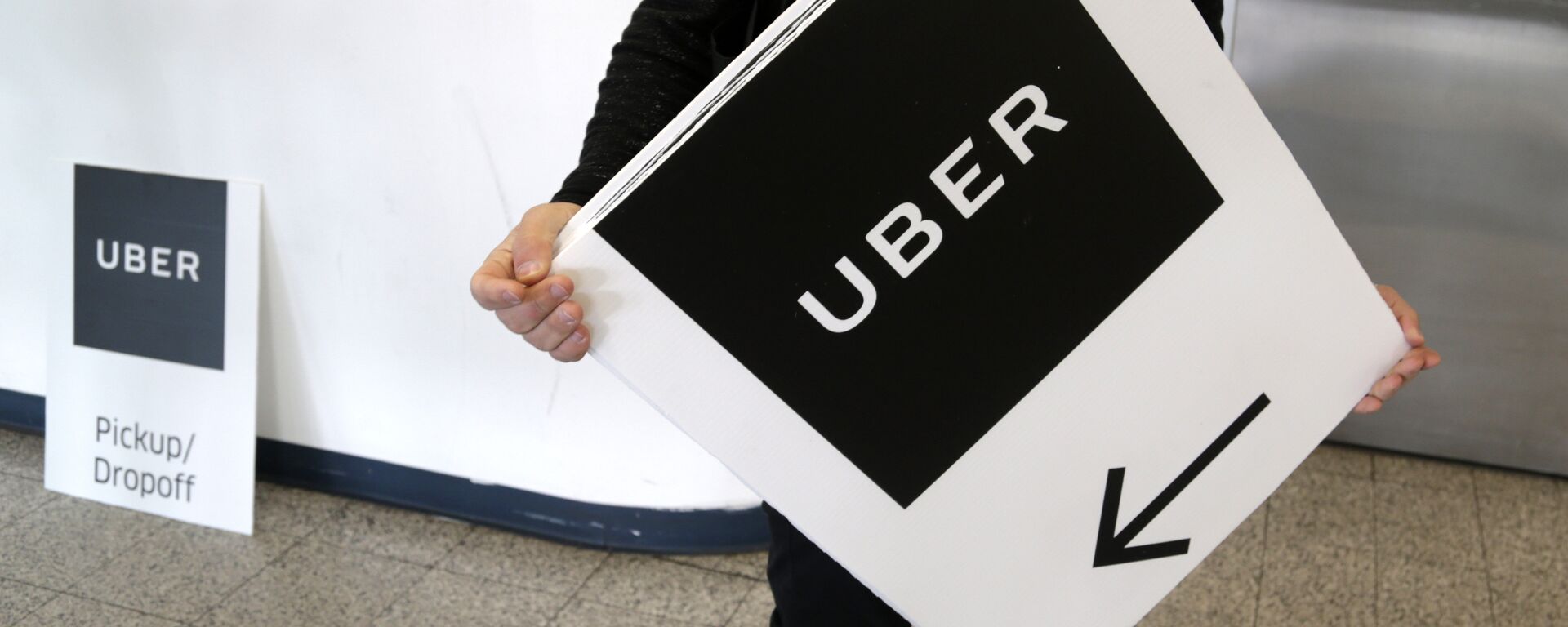 An Uber representative put up signs at LaGuardia Airport in New York, Wednesday, March 15, 2017. - Sputnik International, 1920, 10.11.2021