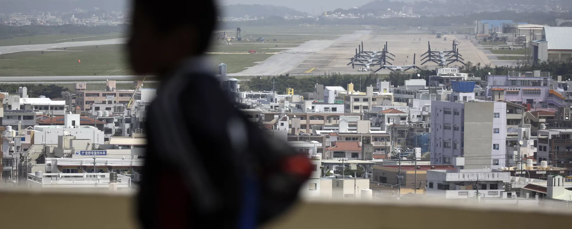 A child looks at the U.S. Marine Corps Futenma Air Station and the surrounding area from an observation deck at a park in Ginowan, Okinawa Prefecture on southern Japan. - Sputnik International, 1920, 16.12.2024