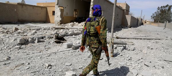 A member of the US-backed Syrian Democratic Forces (SDF), made up of an alliance of Arab and Kurdish fighters, patrols in the town of Al-Karamah, 26 kms from the Islamic State (IS) group bastion of Raqa, as they advance to encircle the jihadists, on March 26, 2017 A member of the US-backed Syrian Democratic Forces (SDF), made up of an alliance of Arab and Kurdish fighters, patrols in the town of Al-Karamah, 26 kms from the Islamic State (IS) group bastion of Raqa, as they advance to encircle the jihadists, on March 26, 2017 - Sputnik International