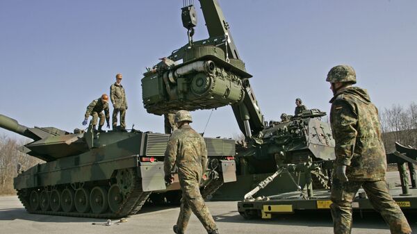 The crew of a 'Buffalo' wrecker tank, right, of the German Army lifts the engine of a Leopard 2 battle tank, left, for repair during a demonstration at the Bayern Barracks in Munich, southern Germany, on Wednesday, Feb. 20, 2008 - Sputnik International