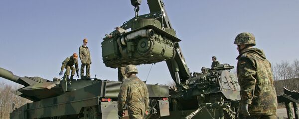 The crew of a 'Buffalo' wrecker tank, right, of the German Army lifts the engine of a Leopard 2 battle tank, left, for repair during a demonstration at the Bayern Barracks in Munich, southern Germany, on Wednesday, Feb. 20, 2008 - Sputnik International