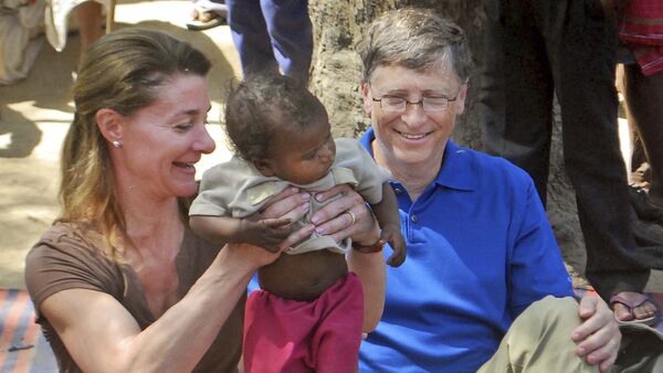 In this Wednesday, March 23, 2011 file photo, Microsoft Corp. founder and philanthropist Bill Gates, right, and his wife Melinda Gates attend to a child as they meet with members of the Mushar community at Jamsot Village near Patna, Indi - Sputnik International