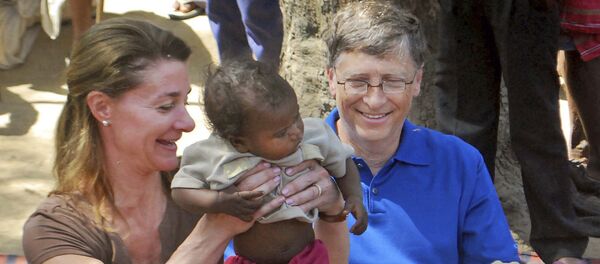 In this Wednesday, March 23, 2011 file photo, Microsoft Corp. founder and philanthropist Bill Gates, right, and his wife Melinda Gates attend to a child as they meet with members of the Mushar community at Jamsot Village near Patna, Indi - Sputnik International