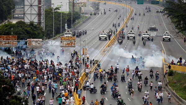 Demonstrators run away from tear gas during clashes with police while rallying against Venezuela's President Nicolas Maduro in Caracas, Venezuela, April 20, 2017. - Sputnik International
