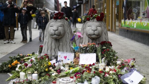 Flowers and candles are placed around stone lions near the department store Ahlens following a suspected terror attack in central Stockholm, Sweden, Saturday, April 8, 2017. - Sputnik International