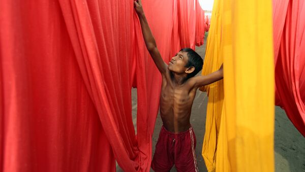 In this Saturday, Dec. 22, 2012 file photo, a Bangladeshi child works at a clothes-dyeing factory in Narayanganj, outskirts of Dhaka, Bangladesh. - Sputnik International