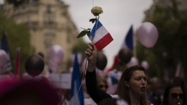 A woman holds a rose and a French flag during a demonstration in what was described as a march of support for all French security forces, in Paris - Sputnik International