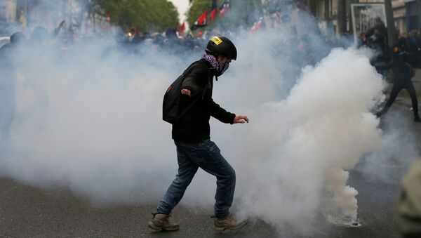 A protester kicks back a tear gas grenade during a demonstration for a social first round on the eve of the first round in the French presidential election, in Paris, France - Sputnik International