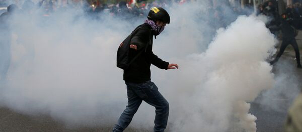 A protester kicks back a tear gas grenade during a demonstration for a social first round on the eve of the first round in the French presidential election, in Paris, France A protester kicks back a tear gas grenade during a demonstration for a social first round on the eve of the first round in the French presidential election, in Paris, France - Sputnik International