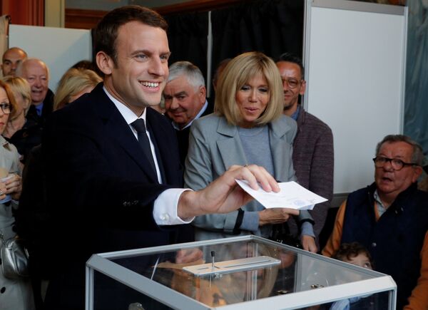 Emmanuel Macron (L), head of the political movement En Marche !, or Onwards !, and candidate for the 2017 French presidential election, casts his ballot in the first round of 2017 French presidential election at a polling station in Le Touquet, northern France, April 23, 2017. At C, his wife Brigitte Trogneux. Emmanuel Macron (L), head of the political movement En Marche !, or Onwards !, and candidate for the 2017 French presidential election, casts his ballot in the first round of 2017 French presidential election at a polling station in Le Touquet, northern France, April 23, 2017. At C, his wife Brigitte Trogneux. - Sputnik International