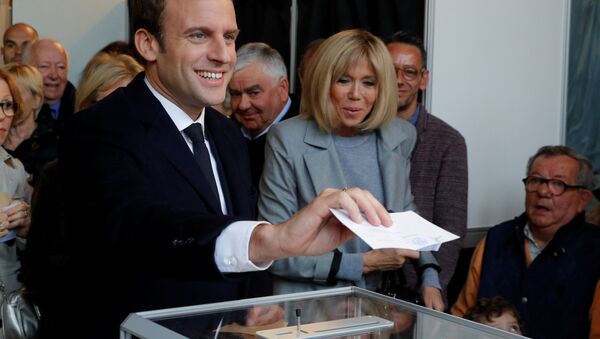 Emmanuel Macron (L), head of the political movement En Marche !, or Onwards !, and candidate for the 2017 French presidential election, casts his ballot in the first round of 2017 French presidential election at a polling station in Le Touquet, northern France, April 23, 2017. At C, his wife Brigitte Trogneux. - Sputnik International