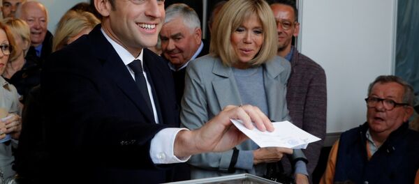 Emmanuel Macron (L), head of the political movement En Marche !, or Onwards !, and candidate for the 2017 French presidential election, casts his ballot in the first round of 2017 French presidential election at a polling station in Le Touquet, northern France, April 23, 2017. At C, his wife Brigitte Trogneux. - Sputnik International