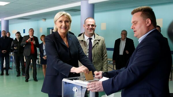 Marine Le Pen (L), French National Front (FN) political party leader and candidate for French 2017 presidential election, casts her ballot in the first round of 2017 French presidential election at a polling station in Henin-Beaumont, northern France, April 23, 2017. At C, Mayor of Henin-Beaumont Steeve Briois - Sputnik International