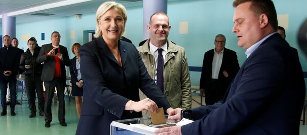 Marine Le Pen (L), French National Front (FN) political party leader and candidate for French 2017 presidential election, casts her ballot in the first round of 2017 French presidential election at a polling station in Henin-Beaumont, northern France, April 23, 2017. At C, Mayor of Henin-Beaumont Steeve Briois - Sputnik International