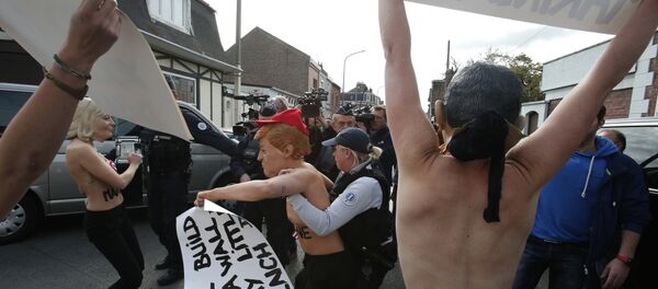 Femen activists, ones wearing the mask of Marine Le Pen, left, and U.S President Donald Trump, center, are detained as they demonstrate in Henin Beaumont, northern France, where far-right leader and presidential candidate Le Pen will vote, during the first round of the French presidential election - Sputnik International
