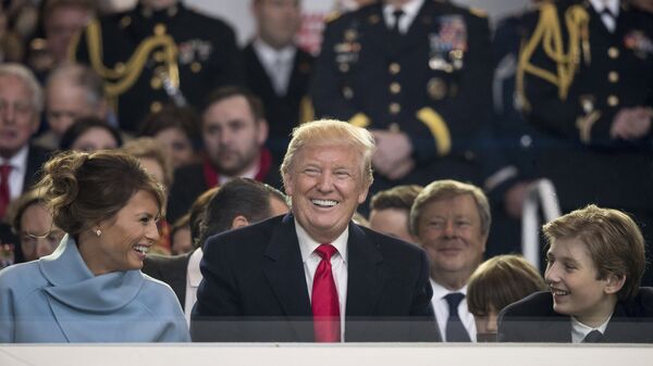 President Donald Trump shares a laugh with first lady Melania Trump and son Barron Trump as they sit in the reviewing stand during Trump's inaugural parade on Pennsylvania Ave. outside the White House in Washington, Friday, Jan. 20, 2017 - Sputnik International