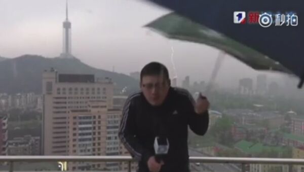 Chinese weather man hit by lightning bolt while holding an umbrella doing LIVE broadcast in a storm - Sputnik International