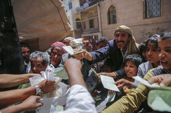 Yemenis receive food rations provided by a local charity, in Sanaa, Yemen, Thursday, April, 13, 2017. - Sputnik International