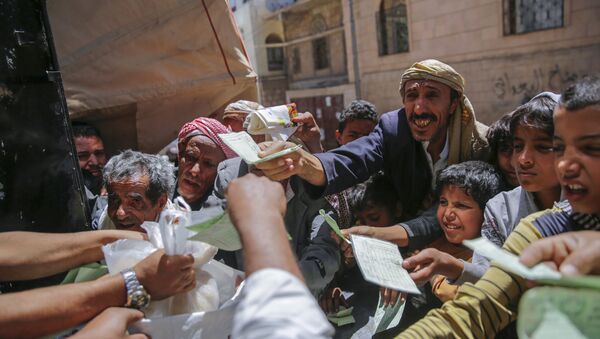 Yemenis receive food rations provided by a local charity, in Sanaa, Yemen, Thursday, April, 13, 2017 - Sputnik International