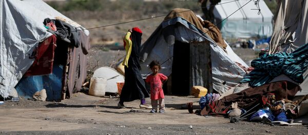 A woman walks past a child at a camp for people displaced by the war, near Sanaa, Yemen April 25, 2017 A woman walks past a child at a camp for people displaced by the war, near Sanaa, Yemen April 25, 2017 - Sputnik International