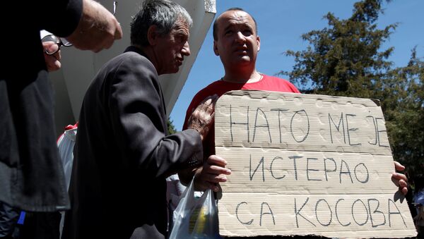 A protester holds a banner that reads NATO forced me out of Kosovo after a protest described as a parallel parliament, ahead of April 28's parliament vote to ratify the Montenegro's NATO membership, in the village of Murino, Montenegro, April 26, 2017 - Sputnik International