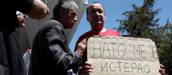 A protester holds a banner that reads NATO forced me out of Kosovo after a protest described as a parallel parliament, ahead of April 28's parliament vote to ratify the Montenegro's NATO membership, in the village of Murino, Montenegro, April 26, 2017 A protester holds a banner that reads NATO forced me out of Kosovo after a protest described as a parallel parliament, ahead of April 28's parliament vote to ratify the Montenegro's NATO membership, in the village of Murino, Montenegro, April 26, 2017 - Sputnik International