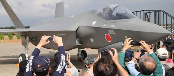 Visitors photograph a mock-up of the F-35 fighter jet displayed at the annual Self-Defense Forces Commencement of Air Review at Hyakuri Air Base, north of Tokyo, Sunday, Oct. 26, 2014 - Sputnik International
