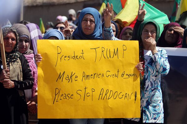 Kurdish women carry flags and a banner as they protest, in the northeastern city of Qamishli, against Turkish airstrikes on the headquarters of the Kurdish fighters from the People's Protection Units (YPG) in Mount Karachok on Tuesday, Syria April 26, 2017 - Sputnik International