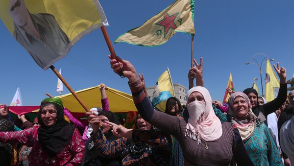 Kurdish women carry flags as they protest, in the northeastern city of Qamishli, against Turkish airstrikes on the headquarters of the Kurdish fighters from the People's Protection Units (YPG) in Mount Karachok on Tuesday, Syria April 26, 2017 - Sputnik International