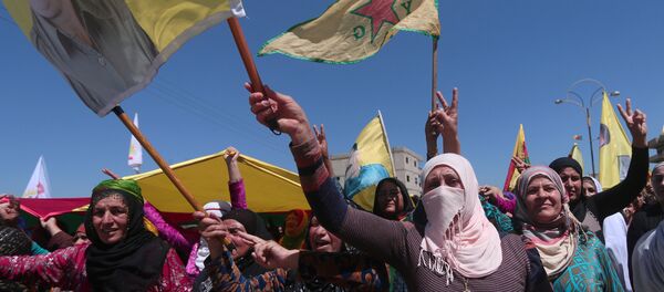 Kurdish women carry flags as they protest, in the northeastern city of Qamishli, against Turkish airstrikes on the headquarters of the Kurdish fighters from the People's Protection Units (YPG) in Mount Karachok on Tuesday, Syria April 26, 2017 - Sputnik International