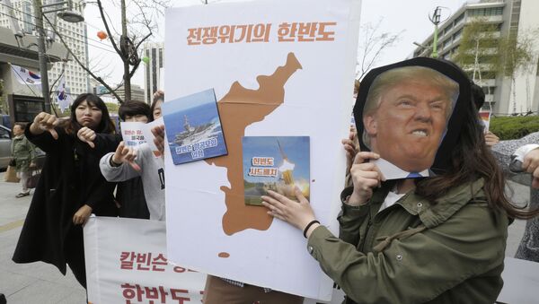 Protesters hold a cutout of U.S. President Donald Trump and images of the USS Carl Vinson aircraft carrier and U.S. missile defense system THAAD, right, on a map of Korean Peninsula during a rally against U.S. deployment of the aircraft carrier to the Korean Peninsula, near the U.S. embassy in Seoul, South Korea, Thursday, April 13, 2017 - Sputnik International