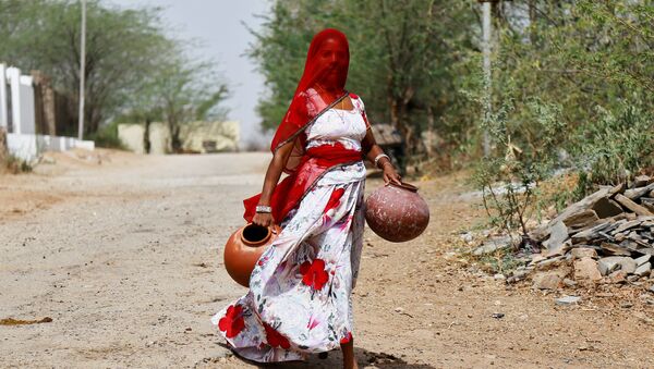 A woman carries earthen pots to fill them with drinking water on a hot summer day, on the outskirts of Ajmer, Rajasthan, India, 25 April 2017.  - Sputnik International
