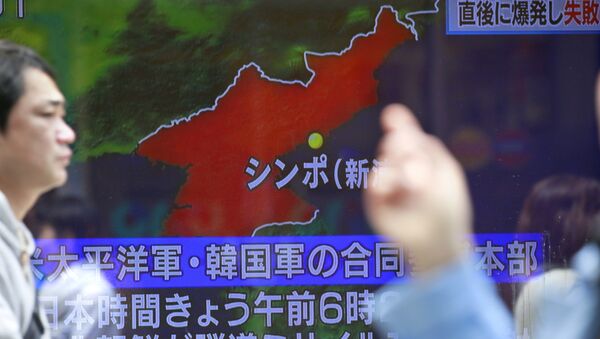 People walk by a TV news showing a map of North Korea with the location of the city of Sinpo while reporting North Korea's rocket launch, in Tokyo, Sunday, April 16, 2017 - Sputnik International