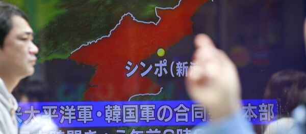 People walk by a TV news showing a map of North Korea with the location of the city of Sinpo while reporting North Korea's rocket launch, in Tokyo, Sunday, April 16, 2017 - Sputnik International