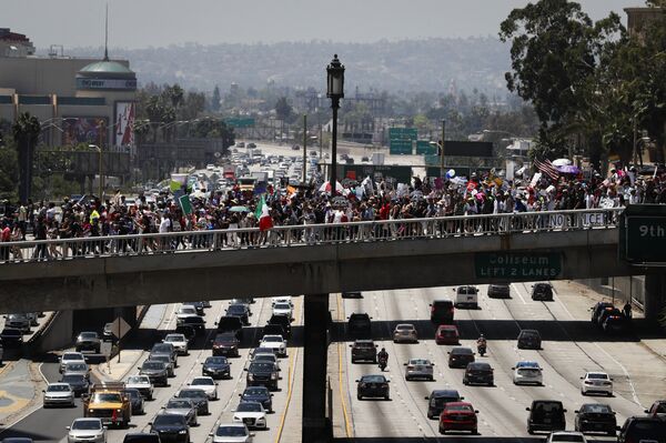 Thousands of protesters march over the 110 Freeway during a May Day rally Monday, May 1, 2017, in Los Angeles. Thousands of protesters march over the 110 Freeway during a May Day rally Monday, May 1, 2017, in Los Angeles. - Sputnik International
