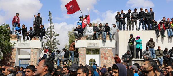 Tunisians wave their national flag as they take part in a general strike against marginalization and to demand development and employment on April 11, 2017, in Tataouine, south of Tunisia Tunisians wave their national flag as they take part in a general strike against marginalization and to demand development and employment on April 11, 2017, in Tataouine, south of Tunisia - Sputnik International