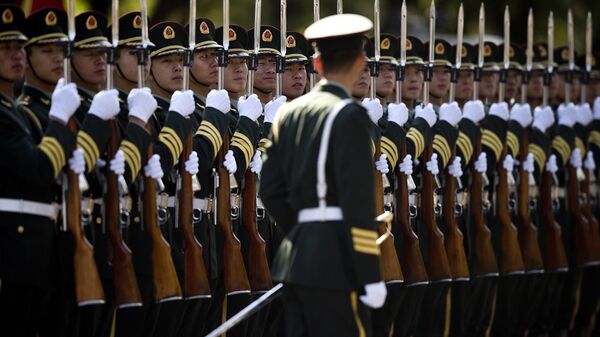 A Chinese People's Liberation Army soldier watches the position of members of a guard of honor as they prepare for a welcome ceremony for visiting Indian Prime Minister Manmohan Singh, outside the Great Hall of the People in Beijing Wednesday, Oct. 23, 2013. - Sputnik International