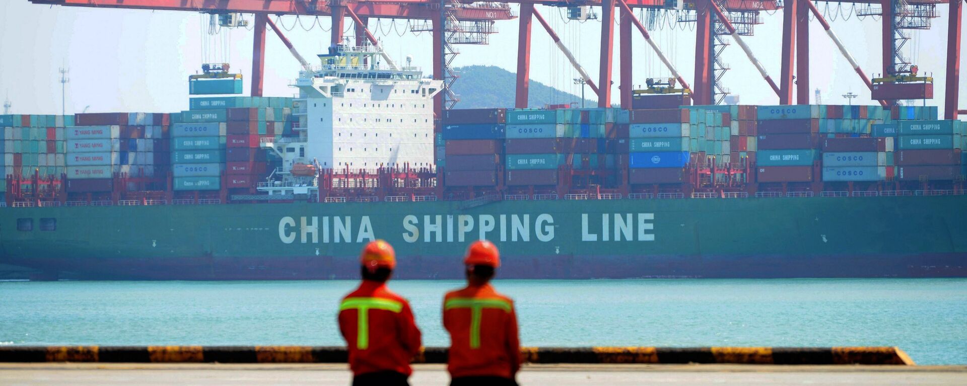 Chinese workers stand on a pier before a cargo ship at a port in Qingdao, east China's Shandong province on 13 April 2017 - Sputnik International, 1920, 23.02.2021
