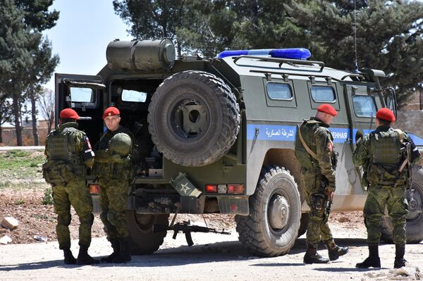 Members of the Russian Military police stand guard in the northern city of Manbij as Syrians who fled the city of Aleppo due to the fighting prepare to return to their hometown, on April 5, 2017 Members of the Russian Military police stand guard in the northern city of Manbij as Syrians who fled the city of Aleppo due to the fighting prepare to return to their hometown, on April 5, 2017 - Sputnik International