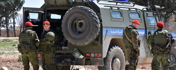 Members of the Russian Military police stand guard in the northern city of Manbij as Syrians who fled the city of Aleppo due to the fighting prepare to return to their hometown, on April 5, 2017 Members of the Russian Military police stand guard in the northern city of Manbij as Syrians who fled the city of Aleppo due to the fighting prepare to return to their hometown, on April 5, 2017 - Sputnik International