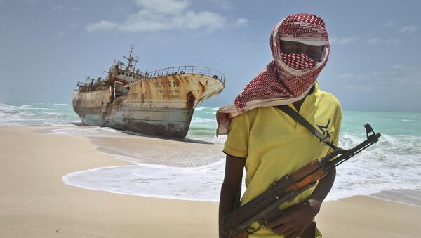 In this Sunday, Sept. 23, 2012 file photo, masked Somali pirate Hassan stands near a Taiwanese fishing vessel that washed up on shore after the pirates were paid a ransom and released the crew, in the once-bustling pirate den of Hobyo, Somalia. - Sputnik International